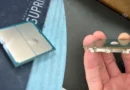 Procesador Ryzen 9 7950X3D en el lado izquierdo con un hueco visible en el sustrato, sostenido con una mano a la derecha.