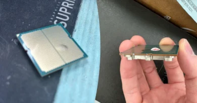 Procesador Ryzen 9 7950X3D en el lado izquierdo con un hueco visible en el sustrato, sostenido con una mano a la derecha.