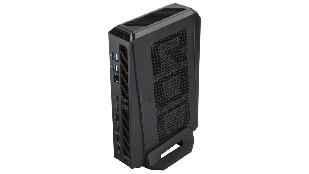 Computadora de formato compacto en color negro, con panel de ventilación, varios puertos USB y conector de audio en la parte trasera.