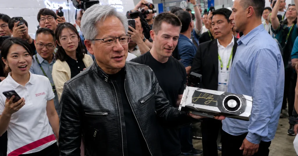 Jensen Huang sostiene una GPU GTX 1080 firmada, rodeado de personas en un evento, todos con sonrisas y cámaras.
