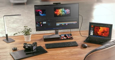 Monitor y portátil en un escritorio, con equipo de edición y cámara; visual de productividad y tecnología.
