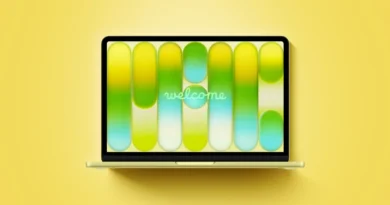 Portátil con pantalla amarilla mostrando un diseño gráfico en tonos verdes y amarillos, con la palabra "welcome" en el centro.