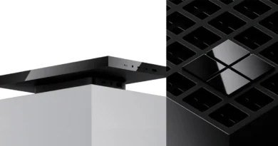 Dispositivo rectangular negro en la parte superior de un soporte blanco, junto a una estructura negra con diseño de rejilla.