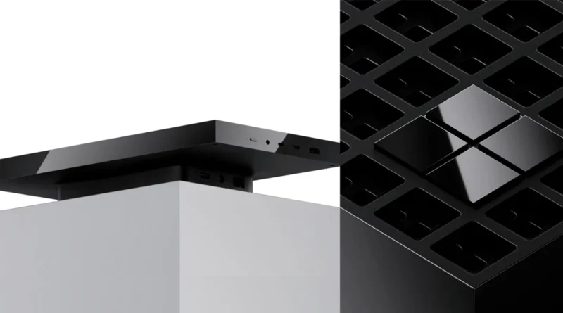 Dispositivo rectangular negro en la parte superior de un soporte blanco, junto a una estructura negra con diseño de rejilla.