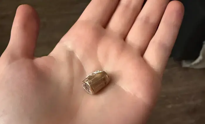 Cápsula de CPU de pequeño tamaño sostenida en una mano, representando componentes de hardware.