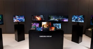 Varias pantallas de Samsung Display muestran contenido vibrante en un entorno minimalista con colores oscuros y una mesa central.