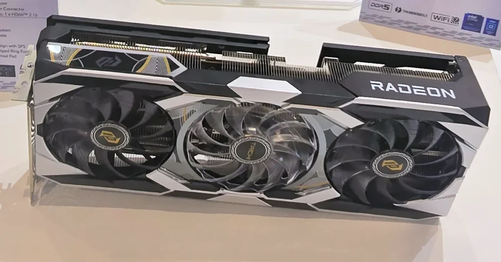 Tarjeta gráfica Radeon RX 9070 XT Taichi con diseño en negro y plateado, tres ventiladores visibles y detalles en amarillo.
