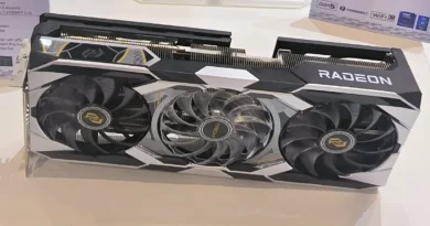 Tarjeta gráfica Radeon RX 9070 XT Taichi con diseño en negro y plateado, tres ventiladores visibles y detalles en amarillo.