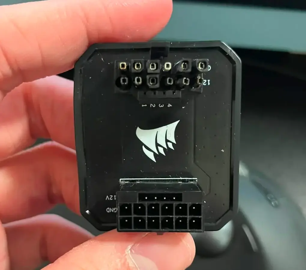 Conector de alimentación Corsair de 24 pines, mostrando múltiples pines para conexiones en hardware de computadoras.