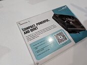 Fondo blanco con un cartel en tonos azul y negro que describe un dispositivo compacto, potente y silencioso, incluye un código QR.