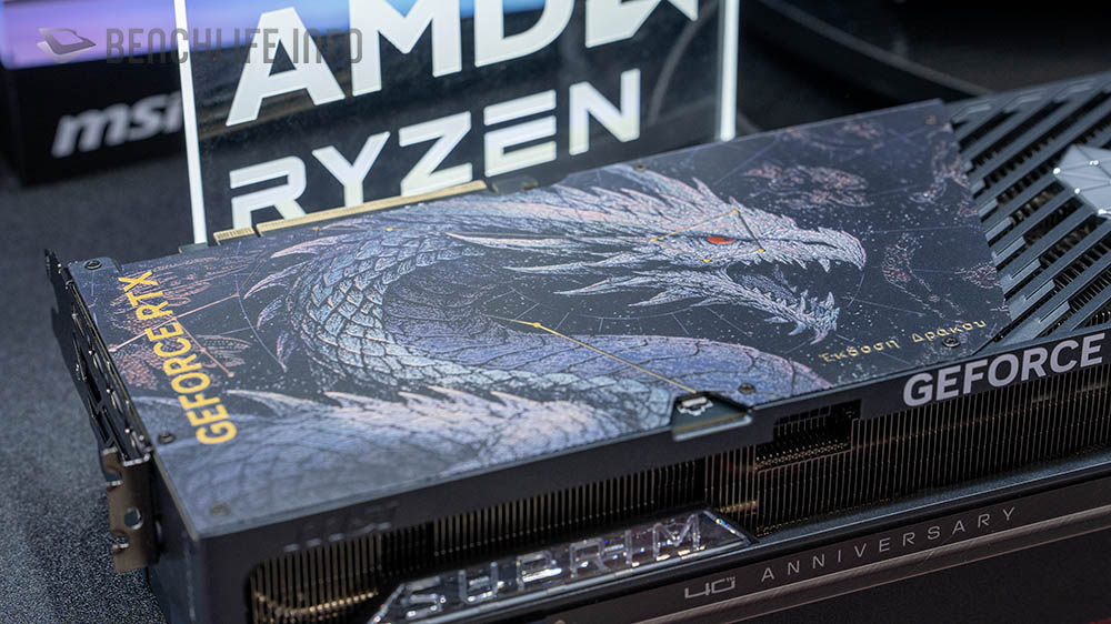 Tarjeta gráfica GeForce RTX con diseño de dragón en tonos oscuros, presentando el logo de 40 aniversario y el nombre de AMD Ryzen al fondo.