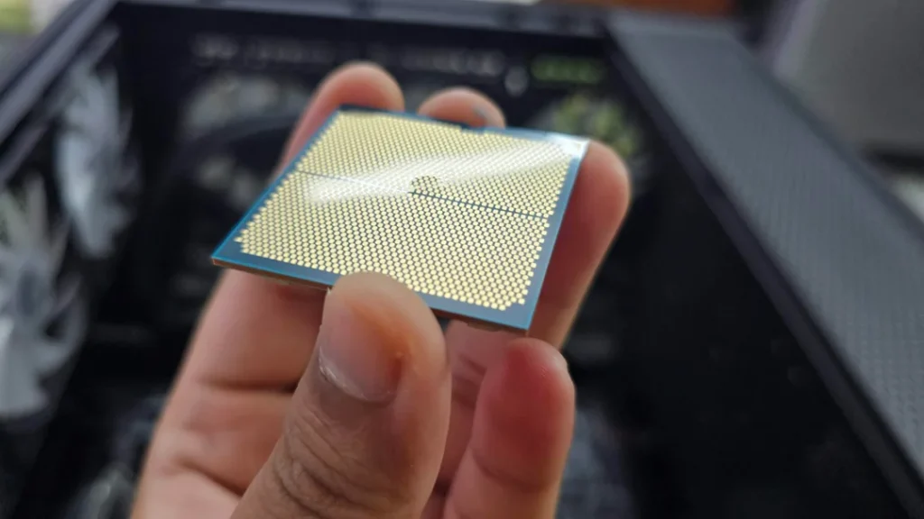 AMD Ryzen 9 9900X en mano, mostrando su superficie de pines, destacando su diseño para rendimiento en gaming y tareas intensivas.