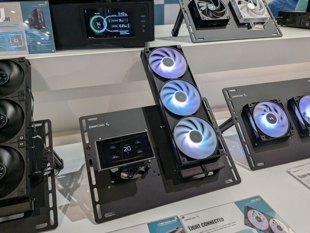 Sistema de refrigeración de PC con ventiladores RGB, pantalla digital que muestra temperaturas y velocidades, fondo blanco.